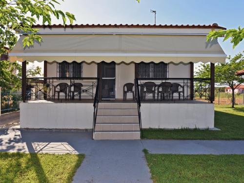 a house with a porch with chairs on it at Mama's Twin Houses by RentalsPro Agios Mamas Halkidiki in Áyios Mámas