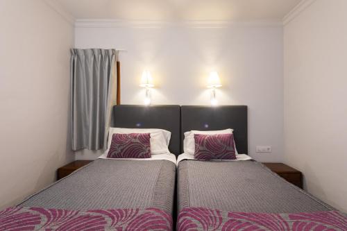 two beds in a small bedroom with two pillows at TC Apartamentos Don Diego in Playa del Ingles