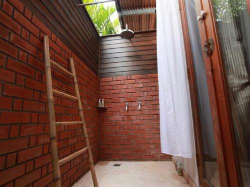 Habitación con pared de ladrillo y escalera. en Baan Tye Wang Guesthouse, en Phra Nakhon Si Ayutthaya