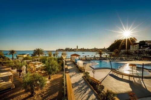 a resort with a pool and the ocean in the background at Valamar Padova Hotel in Rab