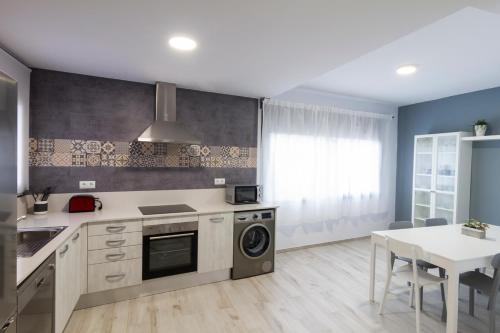 a kitchen with a table and a stove top oven at Casa del Palomet in Deltebre