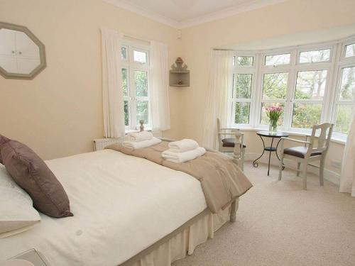 a bedroom with a large bed and a table with chairs at Trelaze in Wadebridge