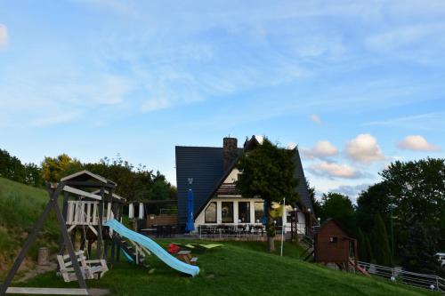a house on a hill with a slide and a playground at MODRA SOBÓTKA - Perła KASZUB in Ręboszewo