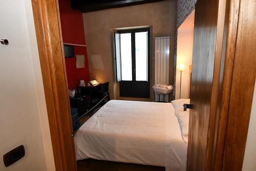 a small room with a bed and a window at Antichi Quartieri in Piazza Armerina