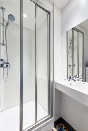 a bathroom with a shower and a sink and a mirror at hotelF1 Mulhouse Centre Ouest in Mulhouse