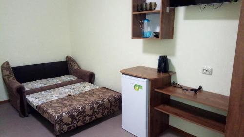 a small room with a small bed and a small cabinet at Отель "Лагита" in Sergeyevka