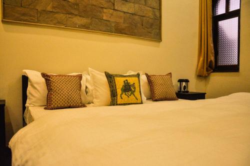 a white bed with pillows on top of it at Hotel Vamdev Fort in Pushkar