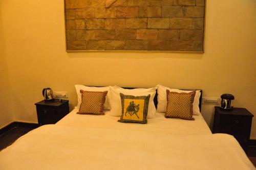 a bedroom with a white bed with pillows at Hotel Vamdev Fort in Pushkar