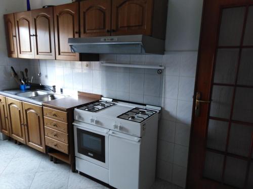 cocina con fogones blancos y fregadero en colors house, en Alghero
