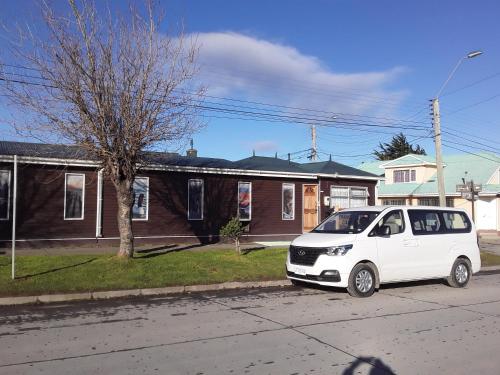 a white car parked on the side of a street at Hostal Don Pedro in Puerto Natales