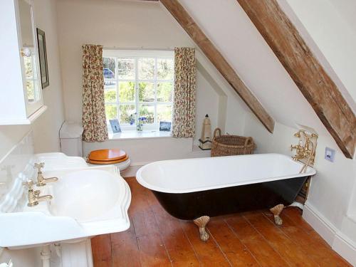 ein Badezimmer mit einer großen Badewanne und 2 Waschbecken in der Unterkunft Rose Cottage in Helston