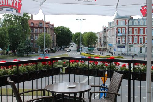 a balcony with a table and chairs and a street at Hotel Piast in Słupsk
