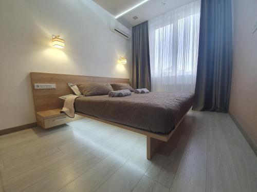 um quarto com uma cama e uma grande janela em LuxApartment em Kiev