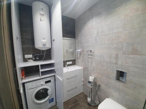 a bathroom with a washing machine and a sink at LuxApartment in Kyiv