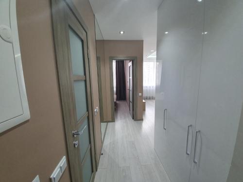 a hallway with white walls and wooden floors and a door at LuxApartment in Kyiv