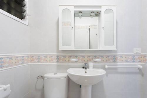 a bathroom with a sink and a toilet and a mirror at Santa Cruz Bolívar Experience in Santa Cruz de Tenerife