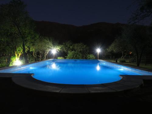 ein großer Swimmingpool in der Nacht mit Lichtern in der Unterkunft Cabañas de los Comechingones in Merlo