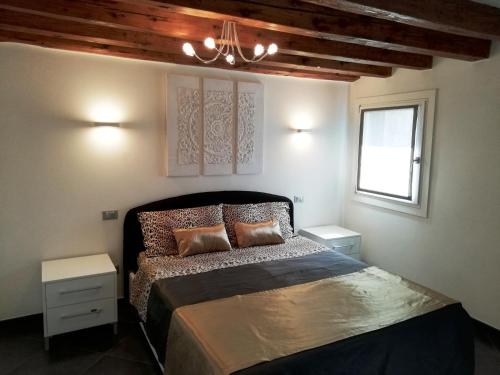 - une chambre avec un lit et un lustre dans l'établissement Cà Mercante di Spezie, à Venise