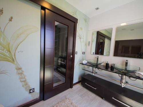 Un baño con dos lavabos y un espejo grande. en Belvilla by OYO Villa Catro Faros, en Montalvo