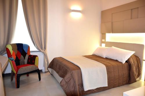 a hotel room with a bed and a chair at Le Suite del Duomo in Cava deʼ Tirreni