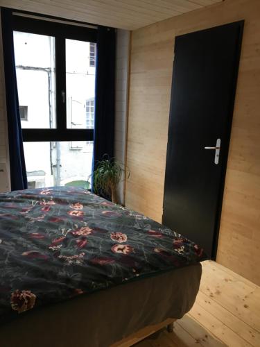 a bedroom with a bed with a black door at le 25bis in Saint-Martory