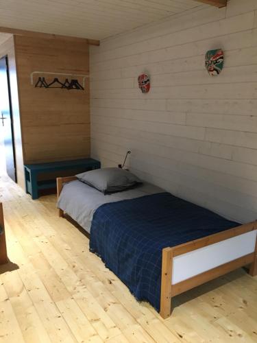 a bedroom with a bed in a room with wooden floors at le 25bis in Saint-Martory
