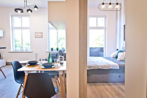 a room with a dining table and a bedroom at Apartament Kalinka in Nysa