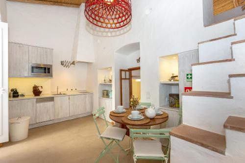 a kitchen with a table and chairs in a room at My Lovely Little House in Loulé
