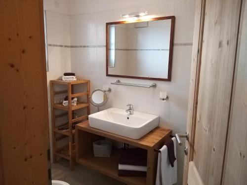a bathroom with a white sink and a mirror at Appartements Josef Lercher in San Candido