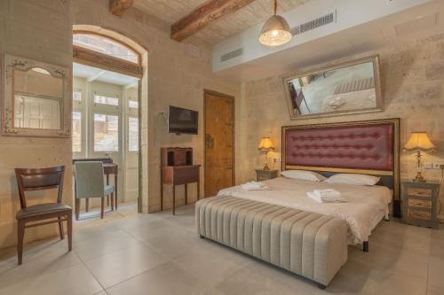 a bedroom with a large bed with a red headboard at Luciano Al Porto Boutique in Valletta