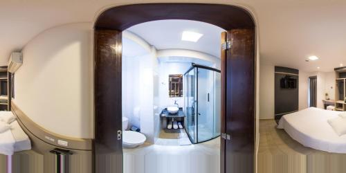 a bathroom with a shower and a toilet in a room at Hollyster Hotel in Curitiba