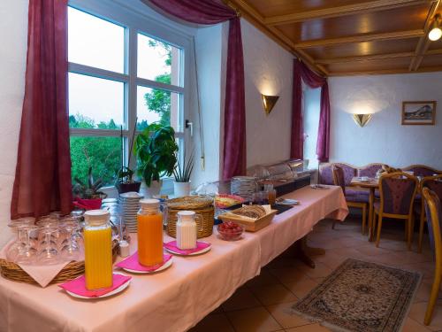 a room with two long tables with orange juice at Hotel Café Alt-Piesport in Piesport