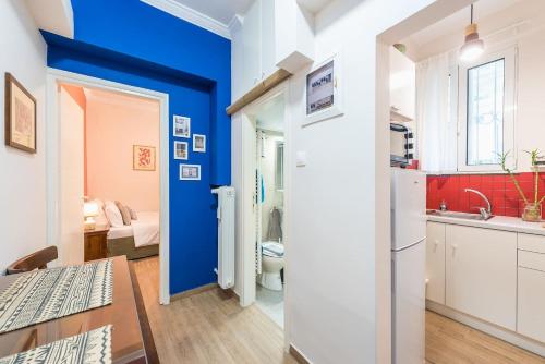 eine Küche mit blauen Wänden, einem Tisch und einem Waschbecken in der Unterkunft Cozy studio 5mins walk from Acropolis museum in Athen