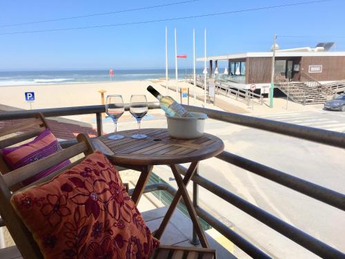 a table with a bottle of wine and two glasses at One of the Best Views Costa Nova II in Costa Nova