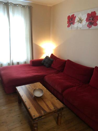 a living room with a red couch and a coffee table at A Stones Throw to the Beach :-) in Weymouth