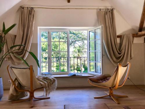 a room with two chairs and a large window at La Maison & L'atelier in Neuilly-en-Thelle