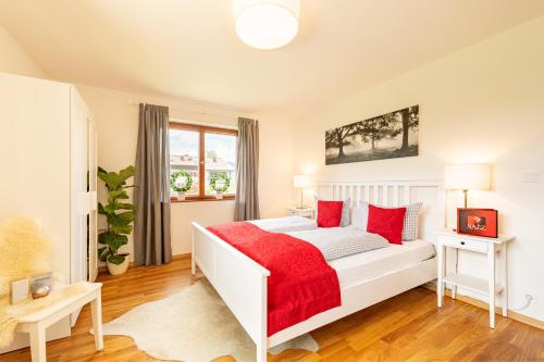 a bedroom with a white bed with red pillows at Ferienwohnung Jasmin in Oberstdorf