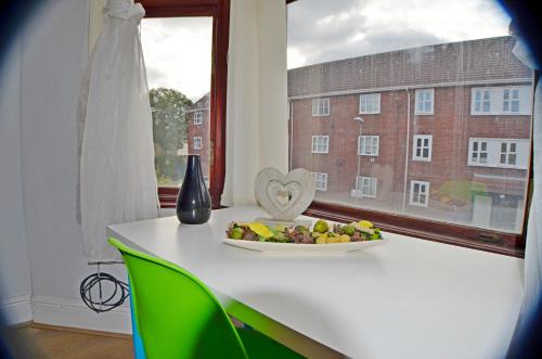 a plate of fruit on a table in front of a window at Kensington Guest House Liverpool in Liverpool