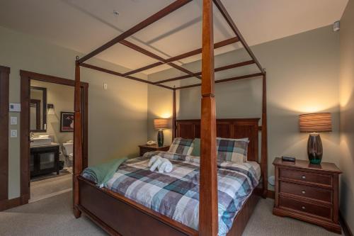 a bedroom with a canopy bed and a bathroom at Étoile du Matin by Rendez-Vous Mont-Tremblant in Mont-Tremblant