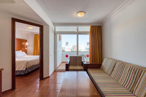 a hotel room with a couch and a bed at TC Apartamentos Dorotea in Playa del Ingles