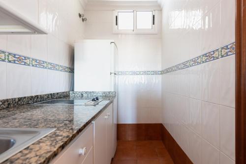 a white kitchen with a sink and a refrigerator at TC Apartamentos Dorotea in Playa del Ingles