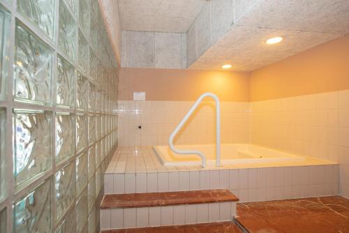 a bathroom with a tub in the middle of a room at Fletcher Hotel-Restaurant Wolfheze in Wolfheze