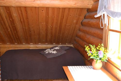 a small room with a bed in a log cabin at Forest Cottage in Säkylä