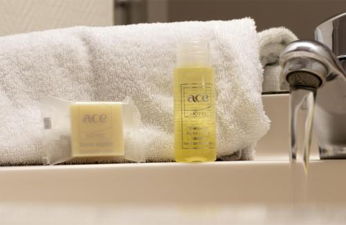 a bathroom counter with a bottle of soap and towels at Ace Hotel Bourges in Bourges