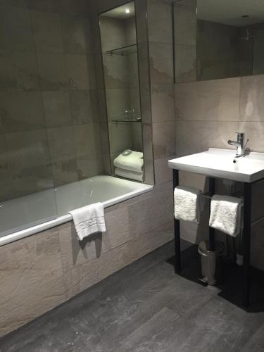 a bathroom with a bath tub and a sink at Grey Street Hotel in Newcastle upon Tyne