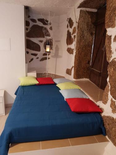 a bed with colorful pillows on it in a room at Casa Bento Teixeira in Belmonte