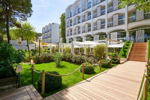 a garden in front of a building at Hotel Saraceno Resort with Private Beach in Milano Marittima