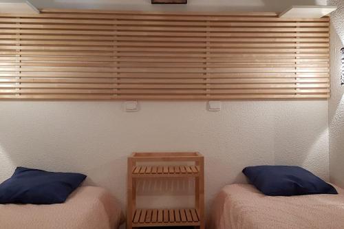 - 2 lits avec des oreillers bleus dans une chambre dans l'établissement Le Skisud Cosy T3 Massif de Ecrins Puy St Vincent 1800, à Puy-Saint-Vincent