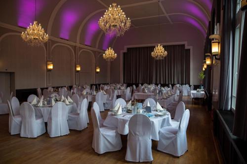a banquet hall with white tables and chairs and chandeliers at Hotel Tenbrock - Restaurant 1905 in Gescher