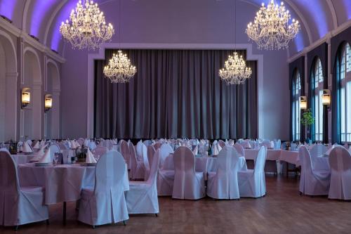 a banquet hall with white tables and chairs and chandeliers at Hotel Tenbrock - Restaurant 1905 in Gescher